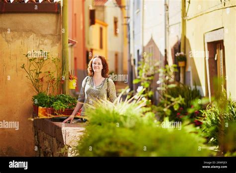 Tourist Girl On A Street Of Bosa With Its Typical Colorful Houses