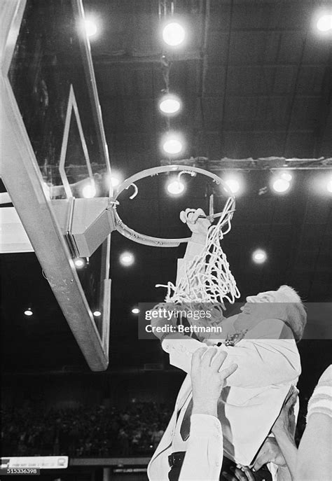 DePaul coach Ray Meyer cuts down the net after the Blue Demons won ...