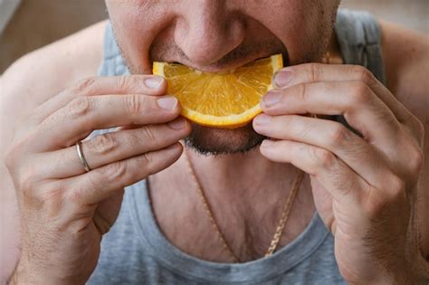 Premium Photo Unrecognizable Middleaged Man Eating An Orange Slice