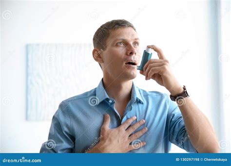 Hombre Joven Que Usa El Inhalador Del Asma Foto De Archivo Imagen De