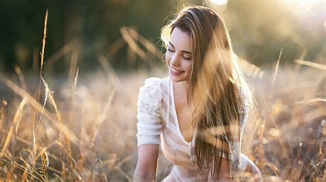 Smiley Blonde Girl Model Is Sitting In Depth Of Field Wearing White