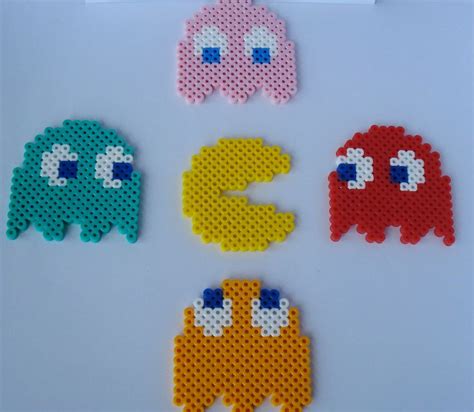 Four Different Colored Pacman Magnets On A White Surface