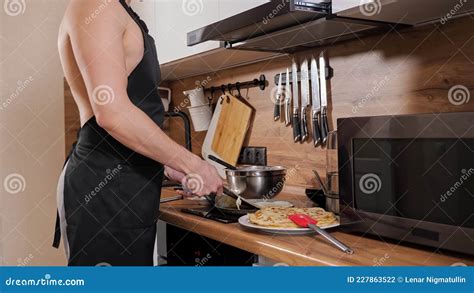 Unrecognizable Man With A Naked Torso And In A Black Apron Prepares