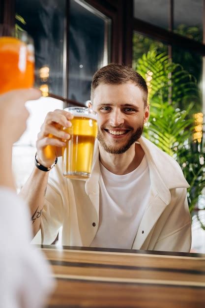 Premium Photo Smiling Attractive Man Is Drinking Beer While Sitting