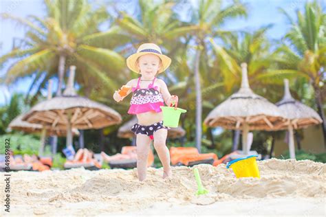 Little girl at tropical white beach making sand castle Stock Photo ...