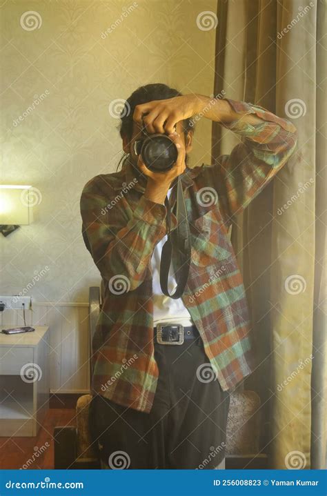 A Male Photographer Taking Selfie With His DSLR Camera In Front Of