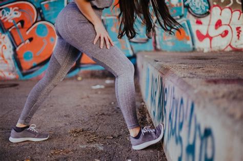 Brunette Mädchen Stretching stehen draußen Kostenlose Foto