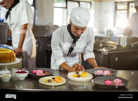 Smiling Female Chef Finishing Dessert Plates Stock Photo Alamy