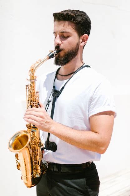 Musicista Concentrato A Tiro Medio Che Suona Il Sax Foto Gratis