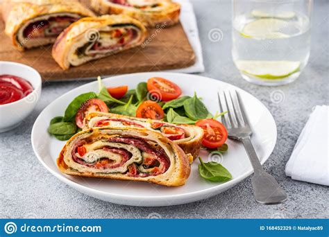 Italian Food Pizza Roll Stromboli With Cheese Salami Spinach And Red Pepper A Light Background