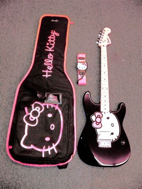 An Electric Guitar And Hello Kitty Case On The Ground