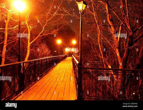 Illuminated street lights and wooden bridge at night Stock Photo - Alamy