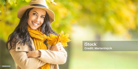 Beautiful Girl Holds Arms Crossed On Her Chest Holding Autumn Leaves Smiling Into The Camera