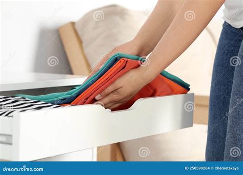 Woman Putting Clean Clothes Into Drawer At Home Closeup Stock Photo