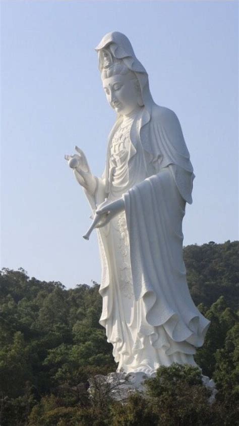 A Large White Statue With Trees In The Background