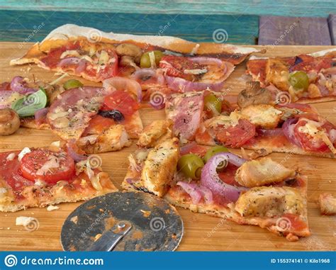 Pizza On Thin Doughwith Slices Of Salami And Ham Olives And Tomatoes