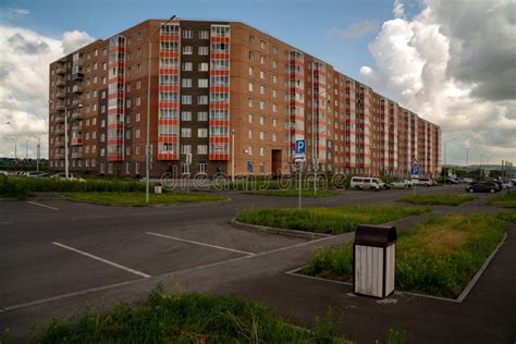 Residential Apartment Building And Parked Cars In A Parking Lot Nearby