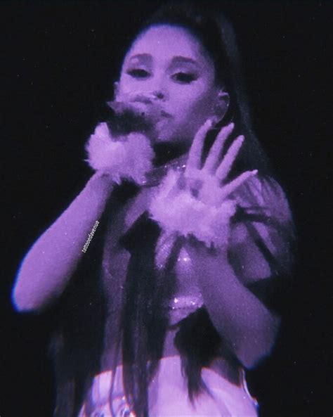 A Woman Holding A Microphone In Her Right Hand And Wearing White