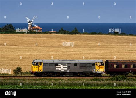 A Railfreight Class 31 Diesel Locomotive Passing Weybourne Windmill On The North Norfolk Railway