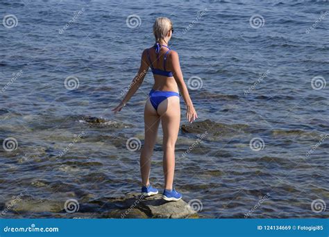 Una Muchacha Hermosa En Un Bikini Azul Camina El Embarcadero Al Mar