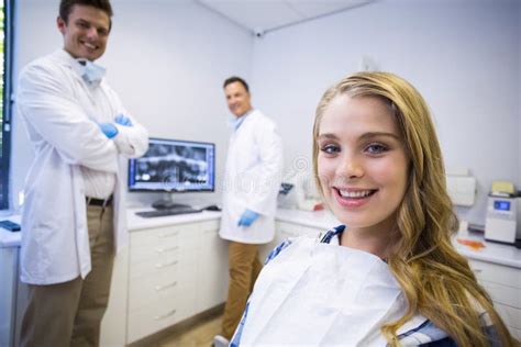 Retrato De Dentistas Sonrientes Y Del Paciente Femenino Foto De Archivo