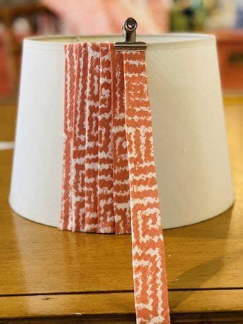 An Orange And White Lamp Shade Sitting On Top Of A Wooden Table