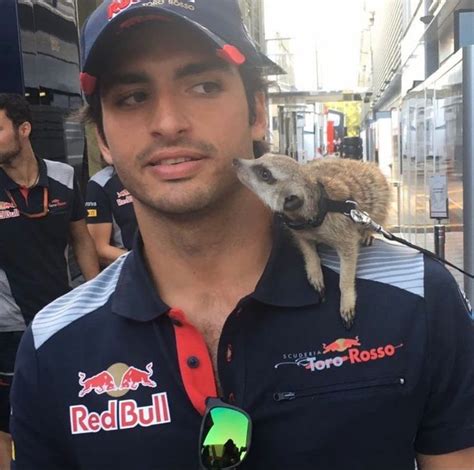 A Man With A Goat On His Shoulder In Front Of Other Men Wearing Red