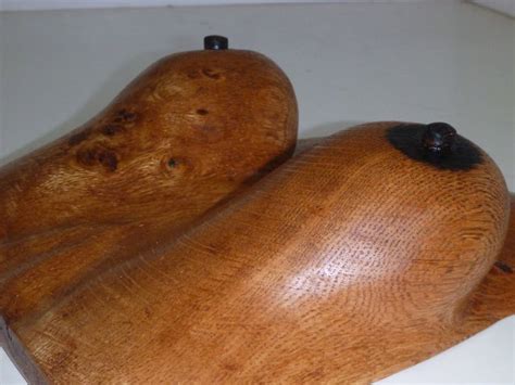 Two Wooden Figurines Sitting Next To Each Other On A White Counter Top