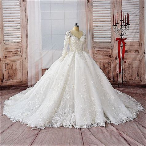 A White Wedding Dress On Display In Front Of Wooden Shutters