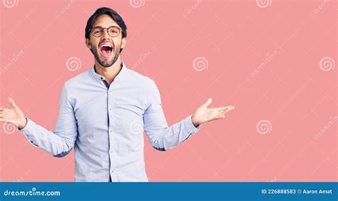 Handsome Hispanic Man Wearing Business Shirt And Glasses Celebrating