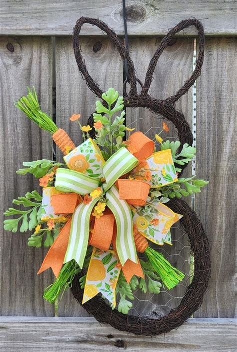 A Wreath With Carrots And Green Leaves Hanging On A Fence