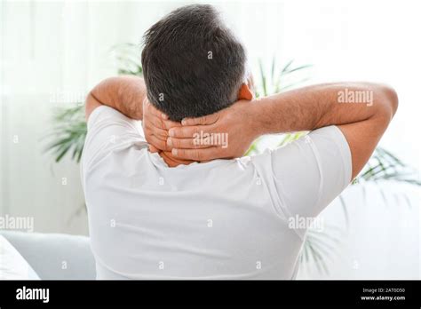 Mature Man Suffering From Neck Pain At Home Stock Photo Alamy