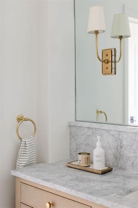 Brass Hulton Sconces on Arched Vanity Mirror in Transitional Bathroom