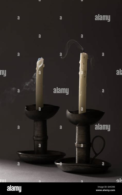 Two Blown Out Smoking Candles On Iron Candlesticks Stock Photo Alamy