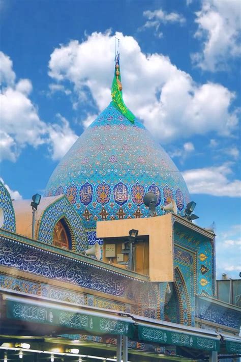 An Ornate Blue And Green Building With Clouds In The Background