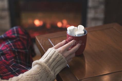 Woman With Cup Of Hot Cocoa And Marshmallow Sitting And Warming At