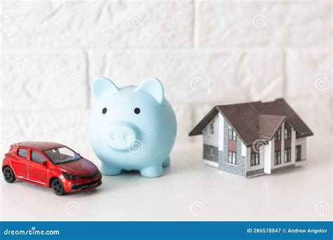 Real Estate House Model With Key And Piggy Bank On Table Stock Image