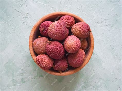 Premium Photo Ripe Lychees On A Green Table Litchi In A Wooden Bowl