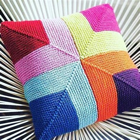 A Multicolored Knitted Pillow Sitting On Top Of A White Chair