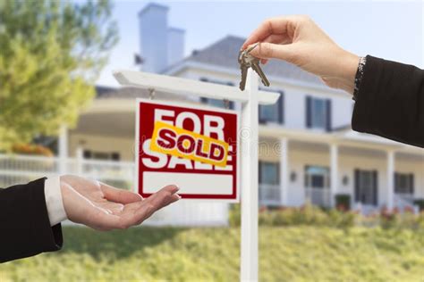 Sold Sign And Agent Handing Over Keys To New Home Stock Photo Image