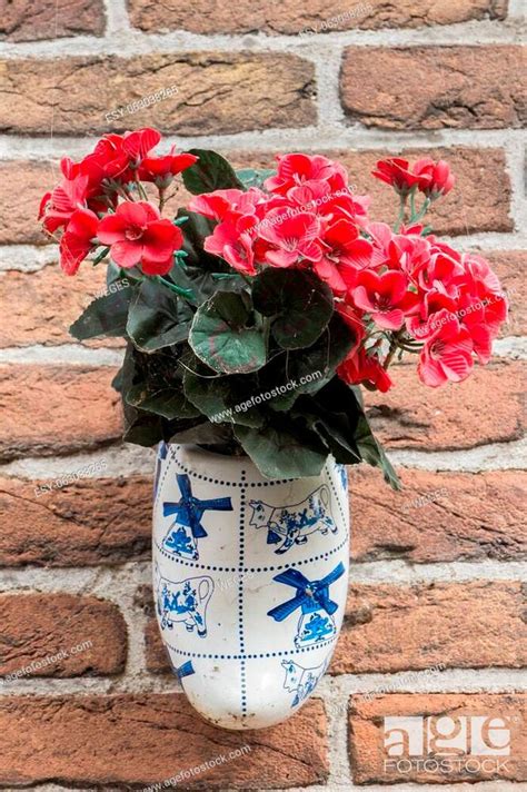 Dutch Wooden Clogs With Pink Flowers Hanging On A Wall Stock Photo