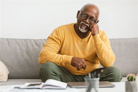 Mature African American Man Sitting On Couch At Home Stock Image