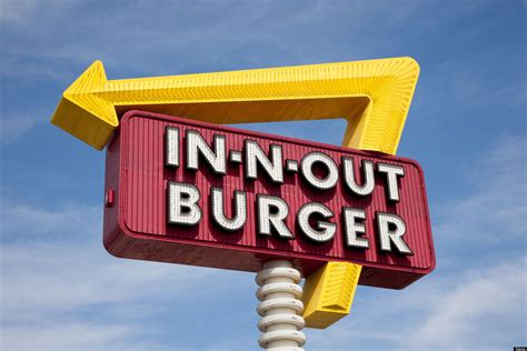 A classic IN-N-OUT BURGER sign in front of blue sky with yellow arrow - Going Global TV