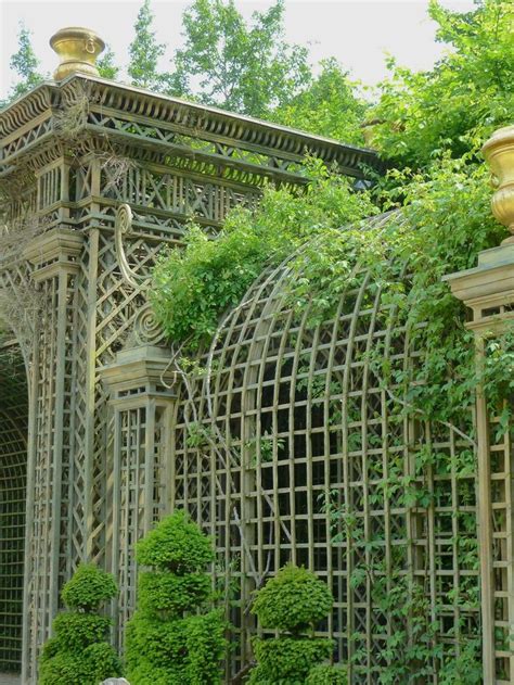 an ornate wooden structure surrounded by trees and bushes