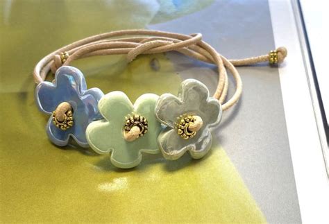 Three Flower Bracelets Sitting On Top Of A Yellow Table Next To A White