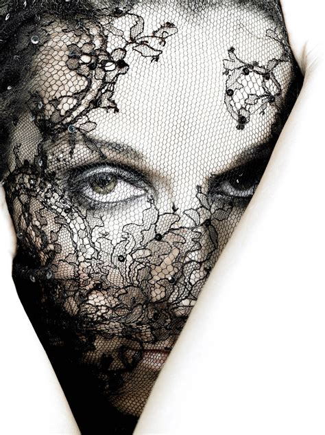 a close up of a person wearing a black lace mask