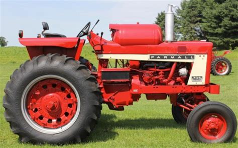 An Old Red Farmall Tractor Parked In The Grass