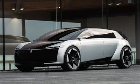 A White And Black Car Parked In Front Of A Building With Glass Doors On