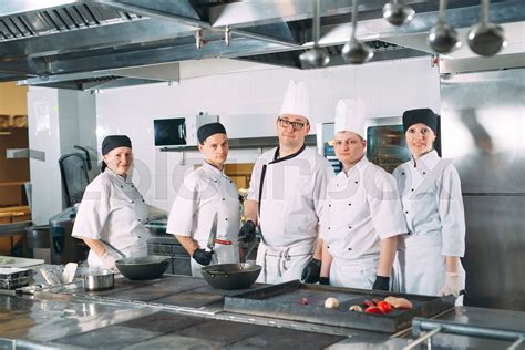 Five Chefs Wearing Uniforms Posing In A Kitchen Stock Image Colourbox