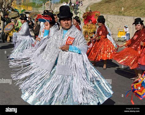 Indigenous women in silver and red traditional dress dancing in street ...